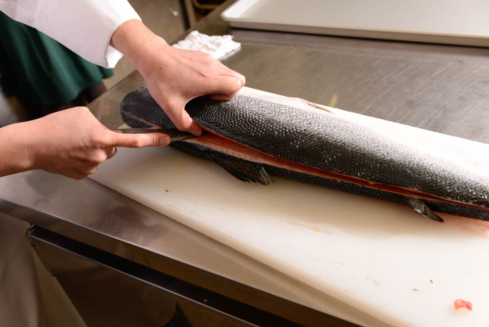 尾から頭に向かって包丁を入れる