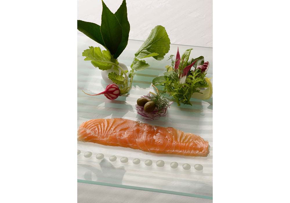 塩気がサーモンの旨味を引き出し、燻香が品よく香る。店ではレモンの葉（左上）を指でくしゅくしゅともんで、指先から香るレモンの清涼感と共に味わうスタイル。ホワイトバルサミコ酢を使ったビネグレットソースで。