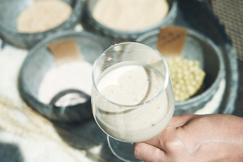 この日のドリンクは動物性素材不使用の「大地のバナナスムージー」。ゴマ、豆乳、米糠、ふすまに木更津ファームの無農薬バナナを皮ごと加えてミキサーでスムージーに。