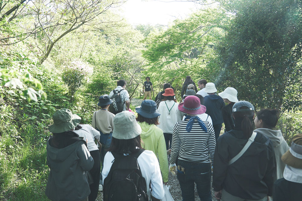 「森を五感で感じてほしい」と吉田さんに導かれて森の中へ。クロモジの葉を手で揉んで香りを嗅いだり、森にもいろんな楽しみ方があります。