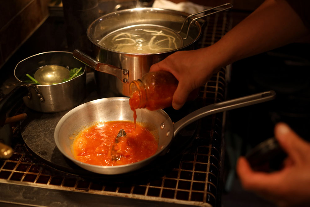 トマトを無農薬栽培する農家から、はち切れんばかりに枝熟した実を仕入れて、その日のうちに加工。驚くほど甘いソースになる。