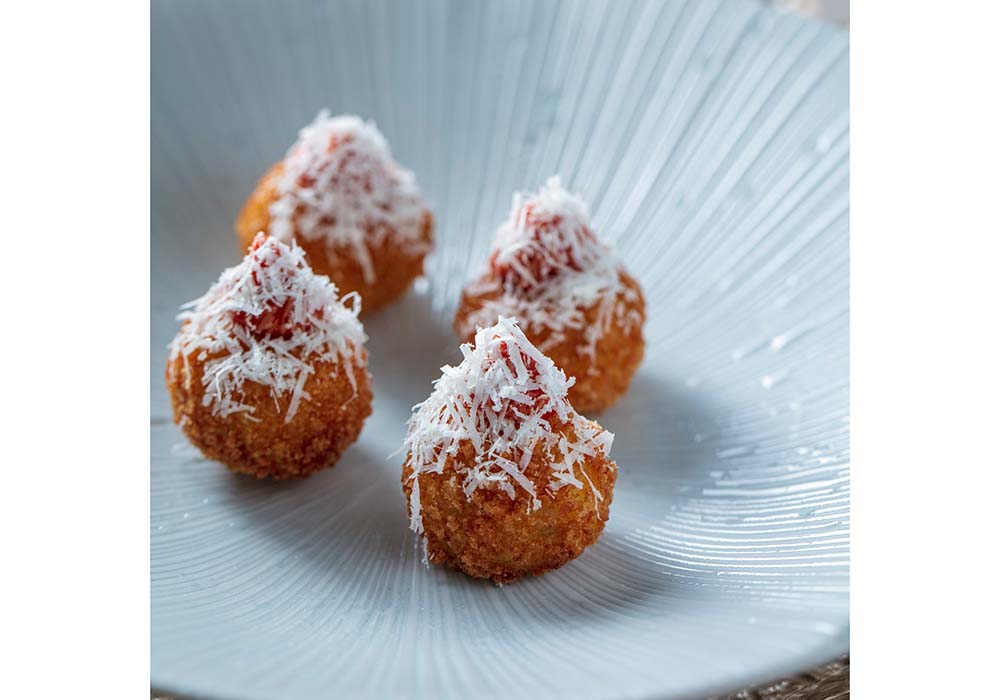 （写真）厨房で余剰食材となった、英国東部サフォーク州産の白カビチーズとして有名なバロン・バイゴットを使ったアランチーニ（ライスコロッケ）。同社のシグニシャー的なカナッペとして人気だ。