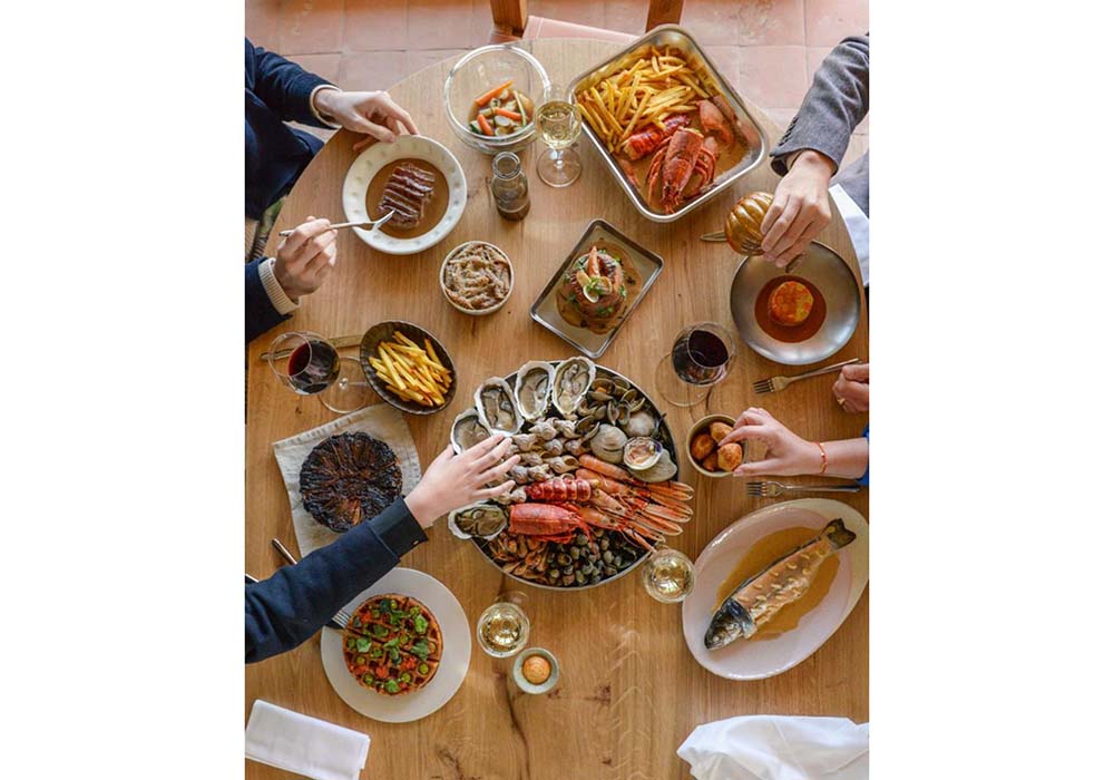 （写真）メニューはとびきり新鮮な魚介類中心。中央：海の幸の盛り合わせ（２人前60ユーロ）、左下：ジャガイモのガレット行者ニンニク風味（12ユーロ）、右下：ニジマスのアーモンド風味（26ユーロ）、右上：ロブスター＆フライドポテト（60ユーロ）。