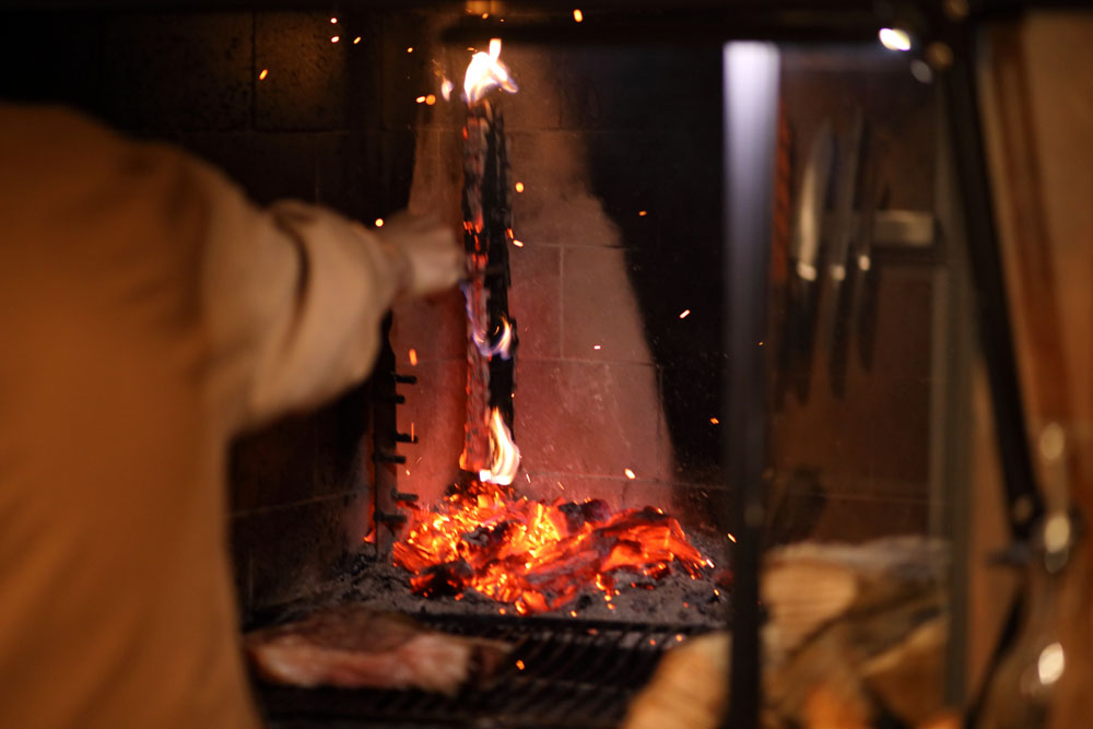 燃えた薪を突き崩して熾火にする。