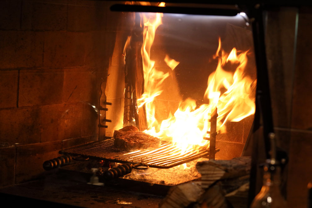 脂が落ち始めたら、扉を開けて空気の流れを作り、落ちた脂が出す煤っぽい煙が肉にまとわりつかないようにする。