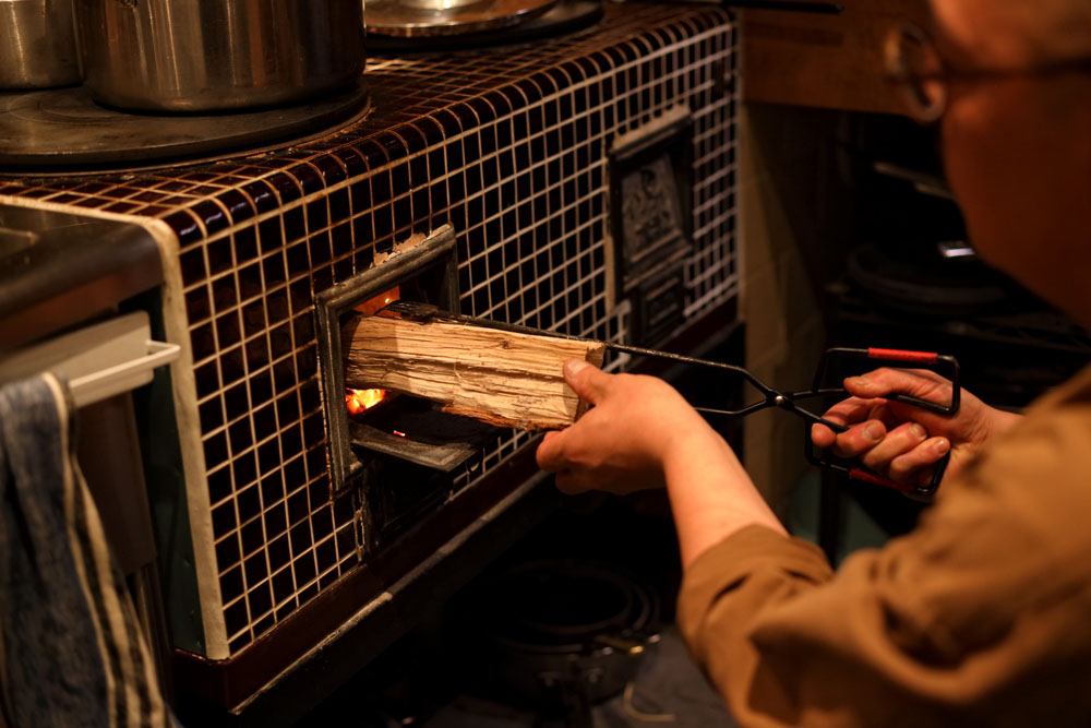 かまどに薪をくべる。蓄熱性が高いので、薪をあまり足さずとも調理が続けられる。