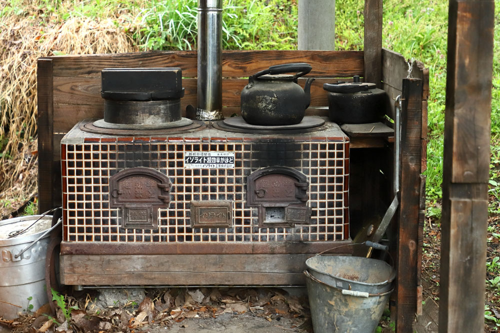 工作室に置かれたイソライト建材製の薪焚かまど。「最近はフレグランスを作る人が蒸溜に使ったりするそうです。薪が手に入る環境に住む人にとっては経済的なんですね」。オフグリッド（！）なので、アウトドアでも大活躍。