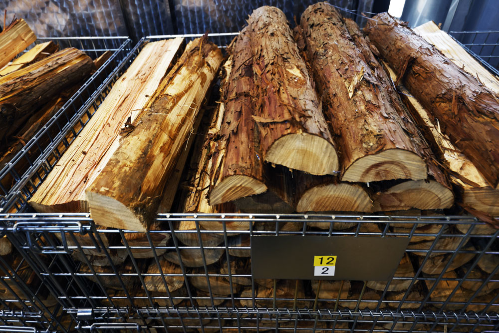 周囲の針葉樹林の間伐材を薪燃料に。木材はスギやヒノキが中心。丸太で運ばれたものを敷地内で薪割りし、数カ月乾燥させてから使う。