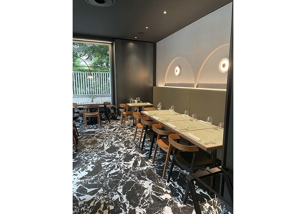 （写真）シンプルでエレガントなテーブルセッティングの店内。主役のピッツァにもきれいに光が当たるよう計算されたライティング。