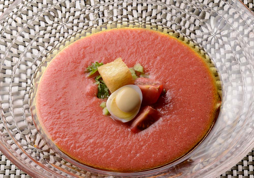 完成。トッピングの揚げパンはトマトとのコントラストを印象づける。 ※写真では、トッピングに動物性食材であるウズラの卵を使用しています。