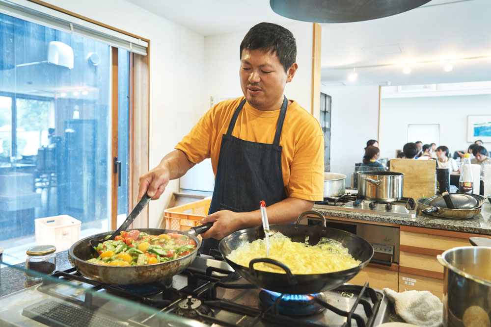 「トマトとオクラと産みたての卵炒め」を調理中。鶏たちが産んだ卵を畑に実った野菜と合わせる。