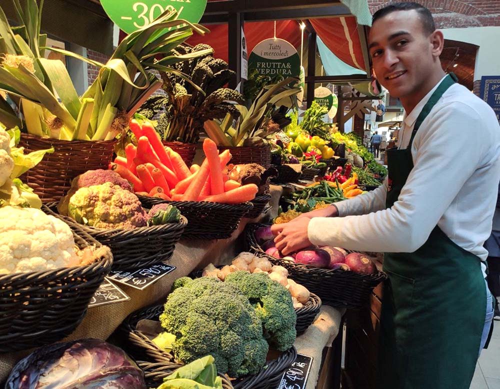 （写真）エジプト出身のカレムさんは、１年前にドバイ、ベイルート、イスタンブールを経由し、粗悪ゴムボートでイタリアに上陸した。プロジェクトを終了した今は、「イータリー・トリノ」の青果コーナーで仕事を学びながら、エジプトの家族に毎月200ユーロ送金できるようになった。