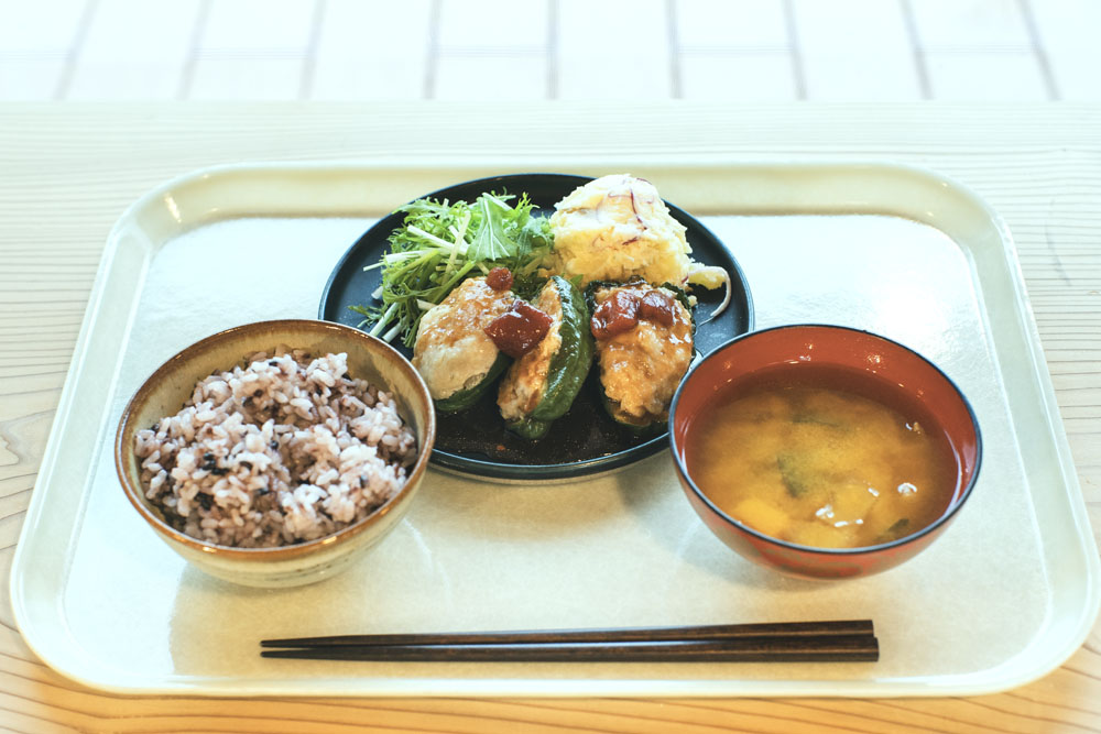 昼の定食：神山で採れたピーマンの肉詰め、黒米ごはん、味噌汁。フードハブ・プロジェクトで４年間農業研修をした後に新規就農した松本直也さん・絵美さん夫妻の農園「oronono」のピーマンが主役。