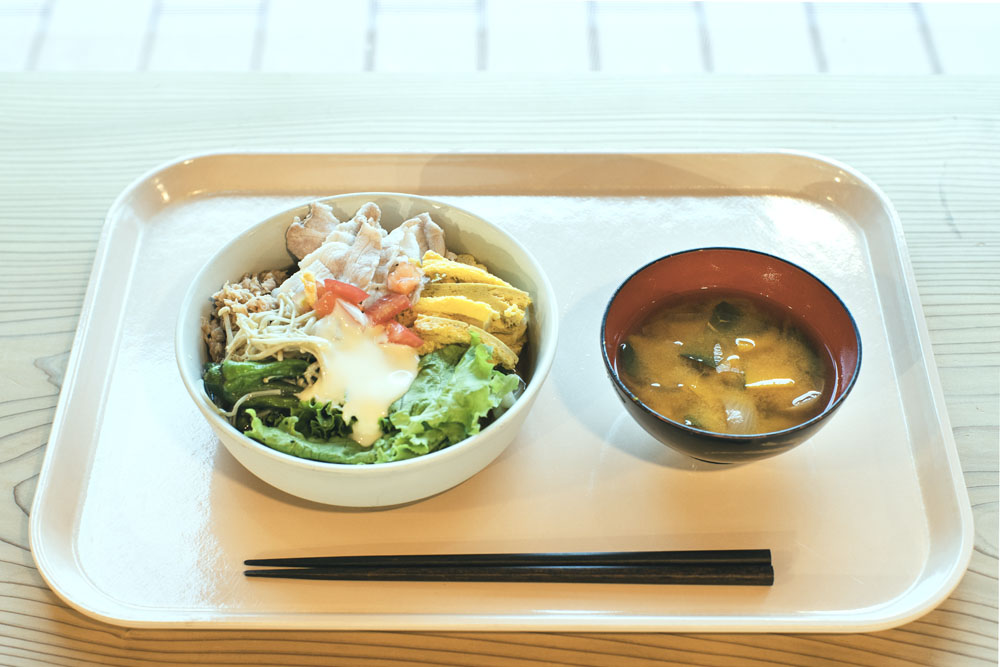 昼の一品料理：豚しゃぶのせサラダうどん、味噌汁。うどんのトッピングは、阿波美豚のバラ肉のしゃぶしゃぶ、厚焼き卵、ツナマヨ、エノキ、トマト、ボリューム満点で若者向け。