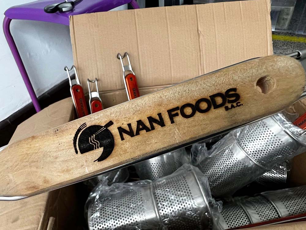 （写真）「湯切り（麺専用の茹でざる）を使わないお客様が多く、驚きました。そこで麺を効率よく、手際よく茹でられるよう、ご契約いただいたお客様には当社ロゴ入り特製湯切りをプレゼントしています」と小林さん。本当においしいラーメンを作ってほしいという姿勢が、信頼とリピートに繋がっている。