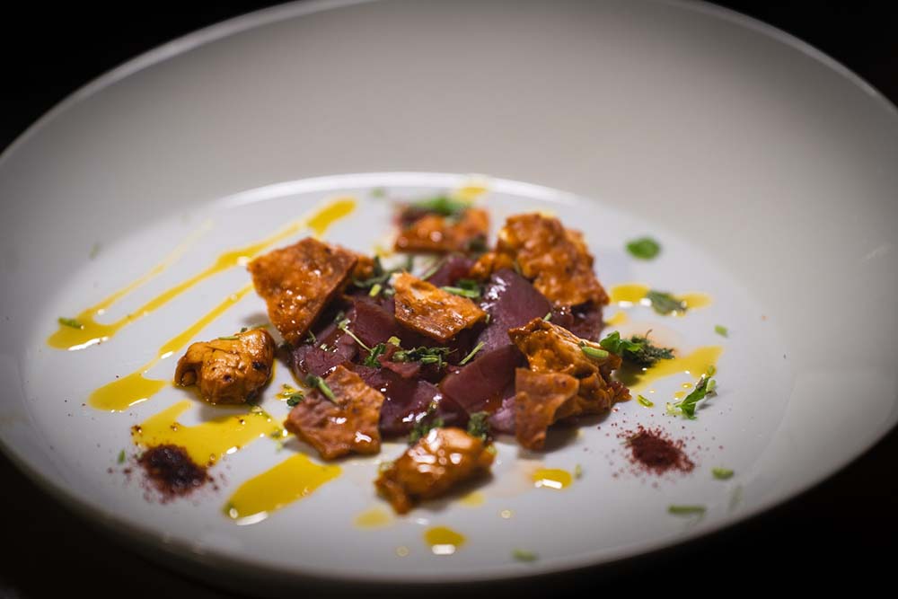 （写真）冷燻製したトナカイ肉、コーヒーでマリネした「カッフェオスト（Kaffeost）」と呼ばれるコーヒーチーズ、揚げた北部地方の薄い固パン、リンゴンベリーパウダー、なたね油。カッフェオストはフィンランド伝統のお茶のお供。コーヒーを飲む時にサイコロ状に切ったチーズを入れる。