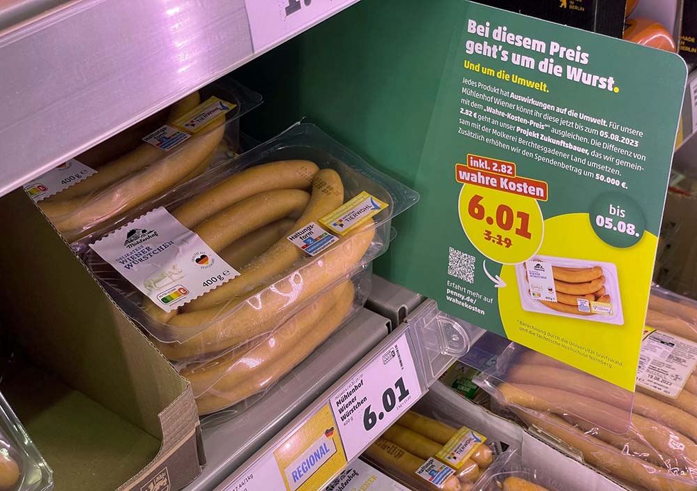 （写真）ウィンナーソーセージは通常価格3.19ユーロに、気候0.94ユーロ、水0.09ユーロ、土壌1.17ユーロ、健康0.62ユーロが加算されて6.01ユーロに（値上がり率88％）。