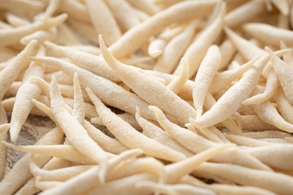 トロフィエは両手のひらですり合わせるように成形し、粉を打ったバットに入れて冷凍。加熱は長めにして、しっかり粉に火を入れる。