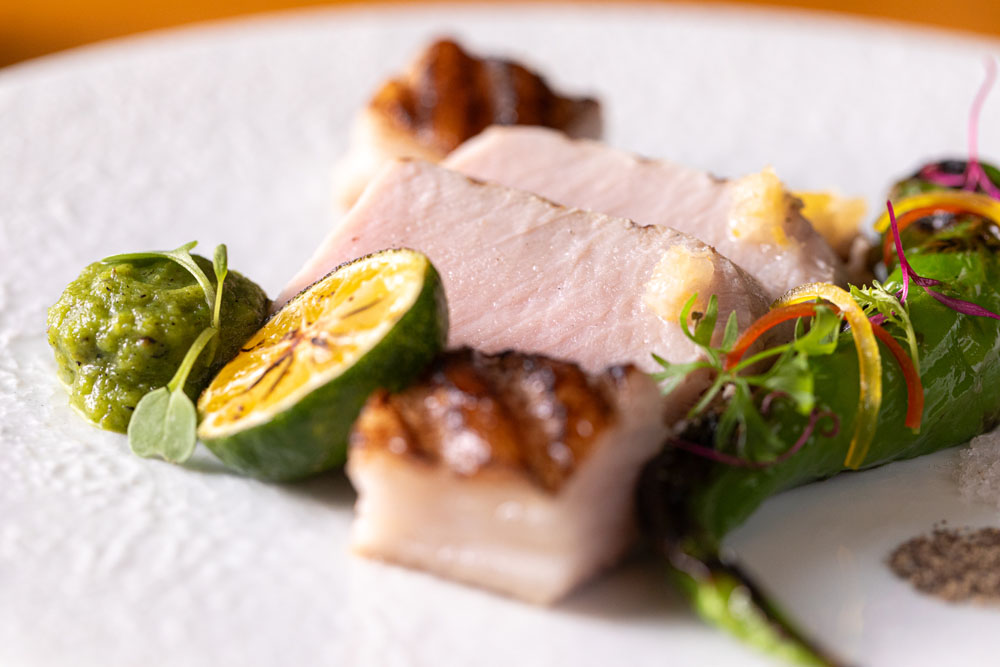 「茨城県武熊牧場“常陸の輝き”ポークロインのグリルと万願寺唐辛子 “マルタマ真レンコン”の蓮根餅　ポークコンソメ」。豚肉の甘味が万願寺唐辛子の辛味で際立つ。