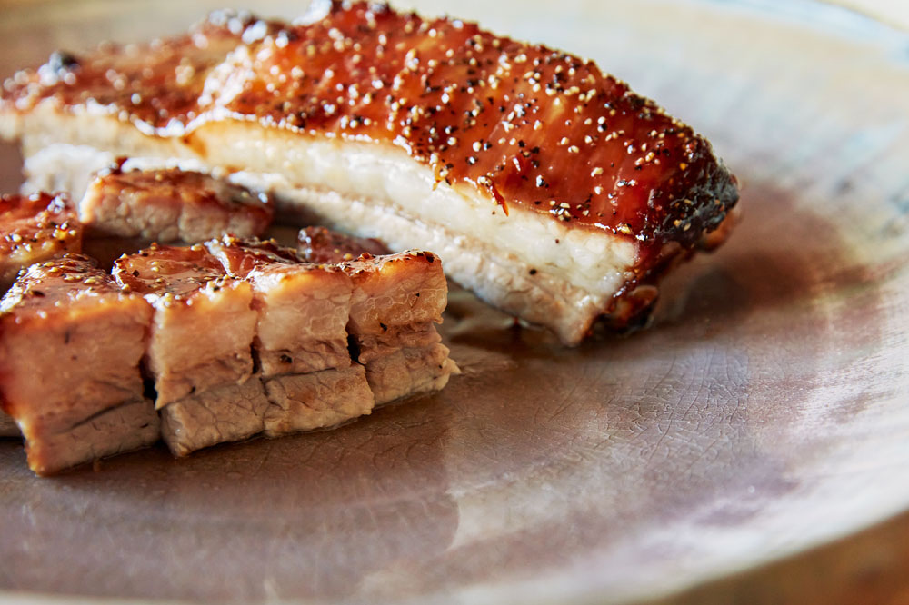 「常陸の輝きスペアリブ　窯焼き叉焼 黒胡椒風味」。器は笠間で作陶する杉山悠氏作。