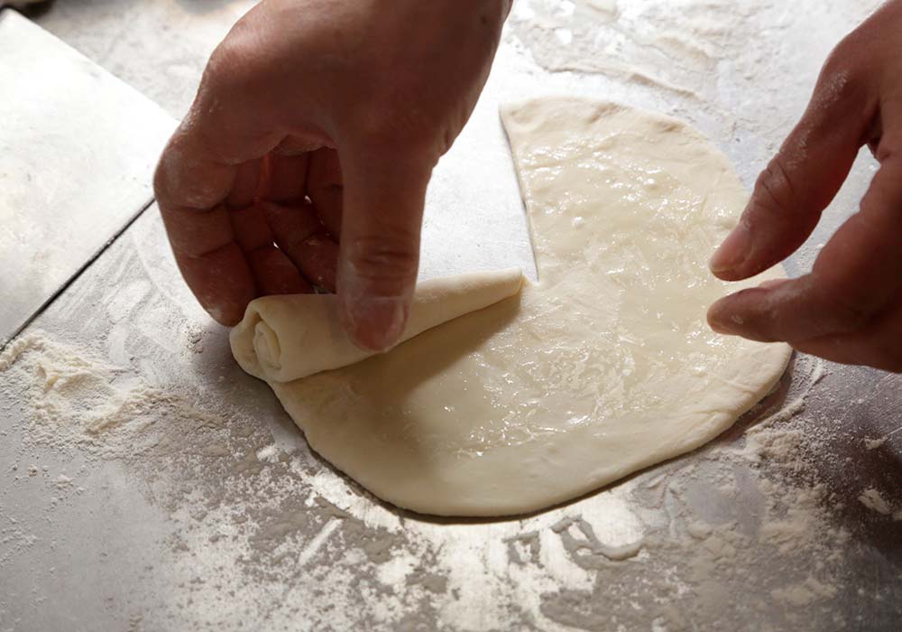 中心に向かって包丁で切れ目を１カ所入れて巻く。