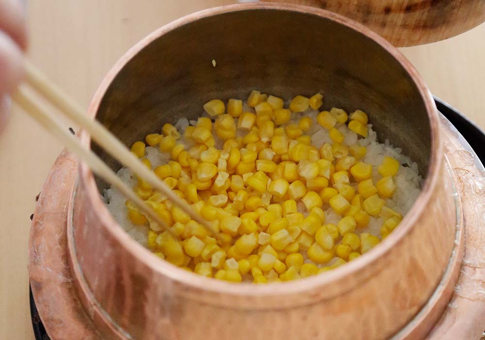 ごはんにトウモロコシの粒を加える