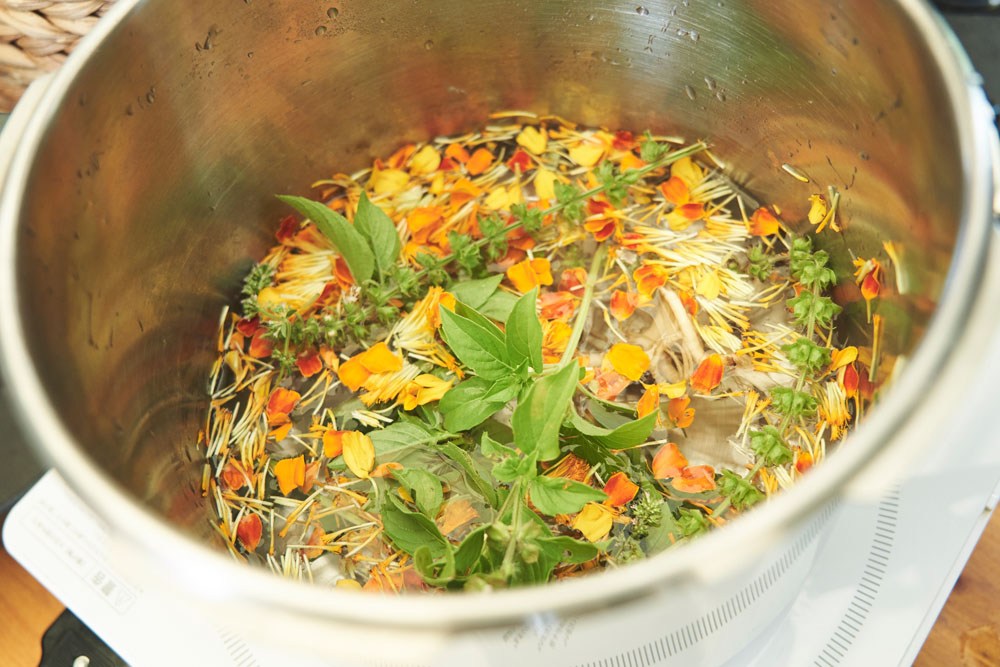 参加者が収穫したハーブを圧力鍋に入れて、水を加え、火にかけます。植物に含まれる成分を蒸気に移して抽出します。