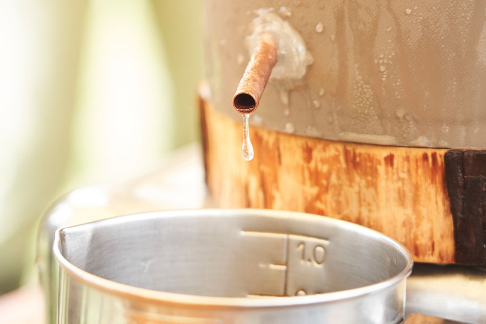 蒸気がシリコンチューブを通ってバケツへ到達し、バケツ内に張り巡らされた銅管へと移動。びっしり詰めた氷に冷やされた銅管を通る間に液体になって滴り落ちる、という仕組み。