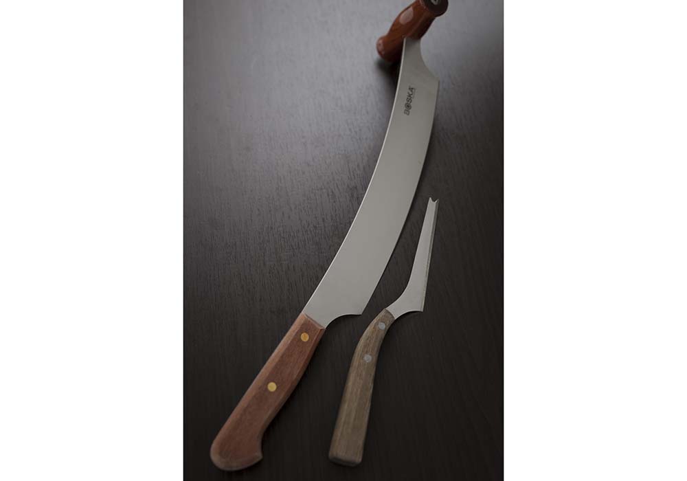 ハードタイプのチーズは基本的にホールで購入し、店の奥にある熟成庫で保管する。通常のチーズナイフのほか、切り出しに利用する大きなナイフも日常必需品だ。