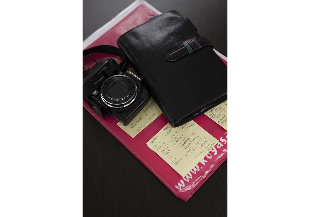 チーズ工房を訪問する際に携帯するデジカメ、手帖、書類の３点セット。書類や手帳には几帳面な文字がびっしり書かれた付箋の数々。前職の仕事柄からか「手帖、付箋使いには自信あります（笑）」と今野さん。