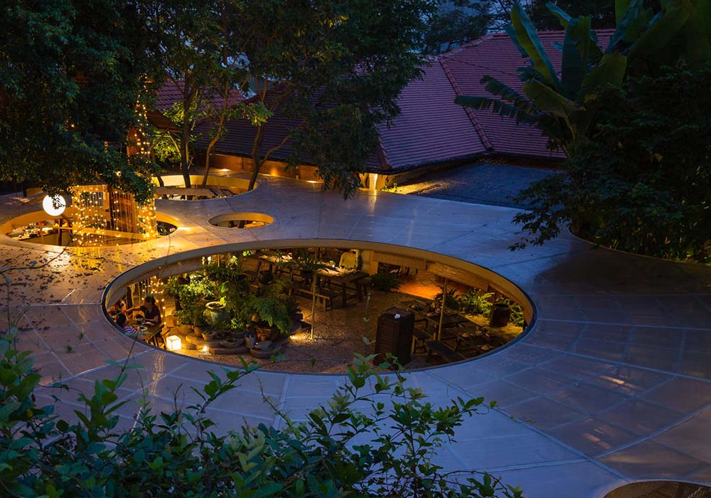 （写真）中央が吹き抜けになっているテラス席は、ライスペーパーを干すための竹網を天井にあしらっている。