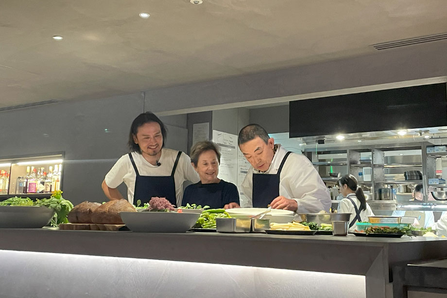 大原で収穫した野菜を使って、中東さんと生江シェフが調理。その横で、アリスがビジネスリーダーたちに向けてスピーチをした。