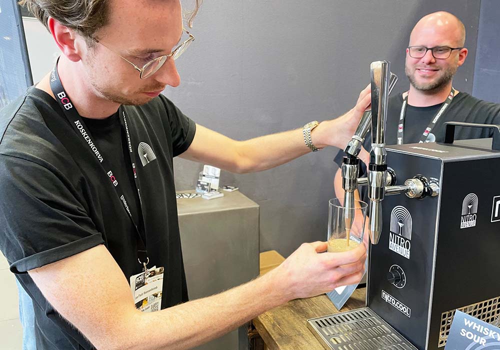 （写真）窒素ガスを使ったカクテルメーカー「NITRO.COOL」も発見。バーテンダーの技の中でも華があるシェイクだが、上手に攪拌し、クリーミーで均一な泡を作るのは簡単ではない。しかし NITRO.COOLを使えば、とろけるような泡に包まれたほろ苦いエスプレッソマティーニや、ピスコサワーなど卵白を使うカクテルが簡単に作れる。「経験を積んだバーテンダーでなくても気軽においしいカクテルが出せますよ」と、NITRO.COOL専用カクテルを開発した「NITRO AVENUE」のユリアン・ネルケ（Julian Nölke）さん（写真左）。