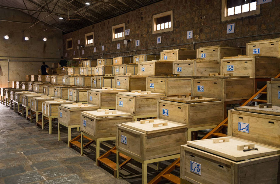 （写真）カカオ豆は農家別に分け、バナナの葉を敷き、蓋を麻袋で覆った木箱で５段階に分けて発酵。よい発酵となるよう祈りを込めて、木箱の前にムグルと呼ばれる伝統的な吉祥模様を毎朝描く。発酵・乾燥した豆は６〜９カ月間熟成させた後、カールカーナーに運ばれる。photo by Daksh Chindalia