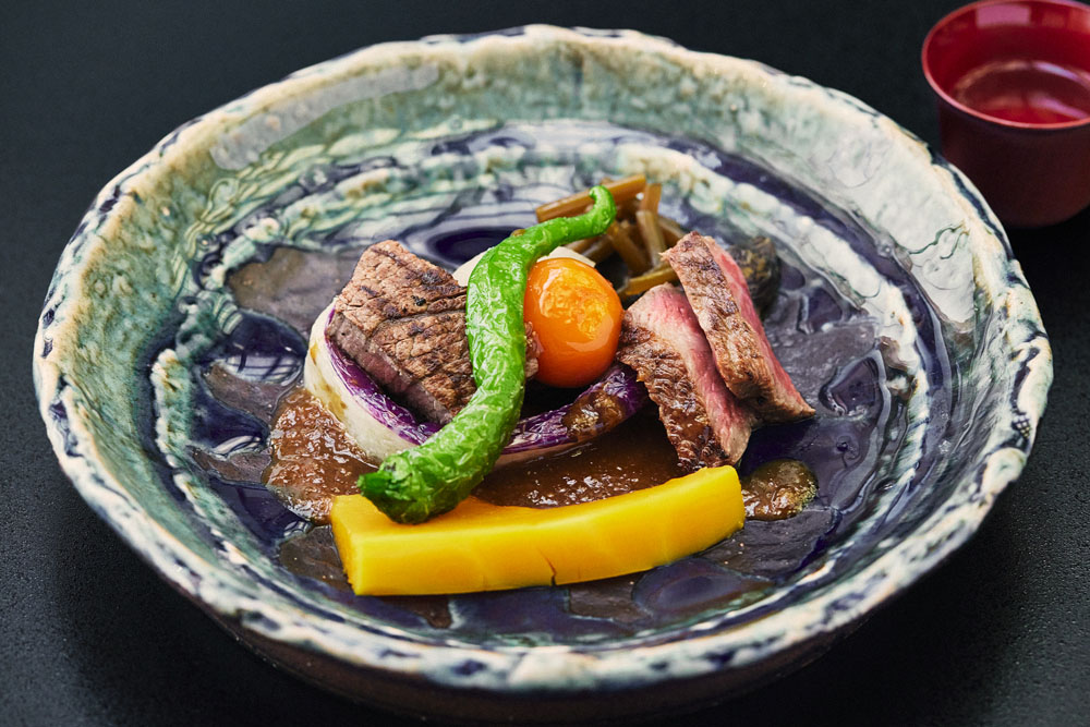 脂身が少なく、やわらかい赤身の「みっかび牛」を酒粕味噌に漬け込んで炭火焼に。栄醤油の醤油で漬けた茎わさびと卵黄を添えて。