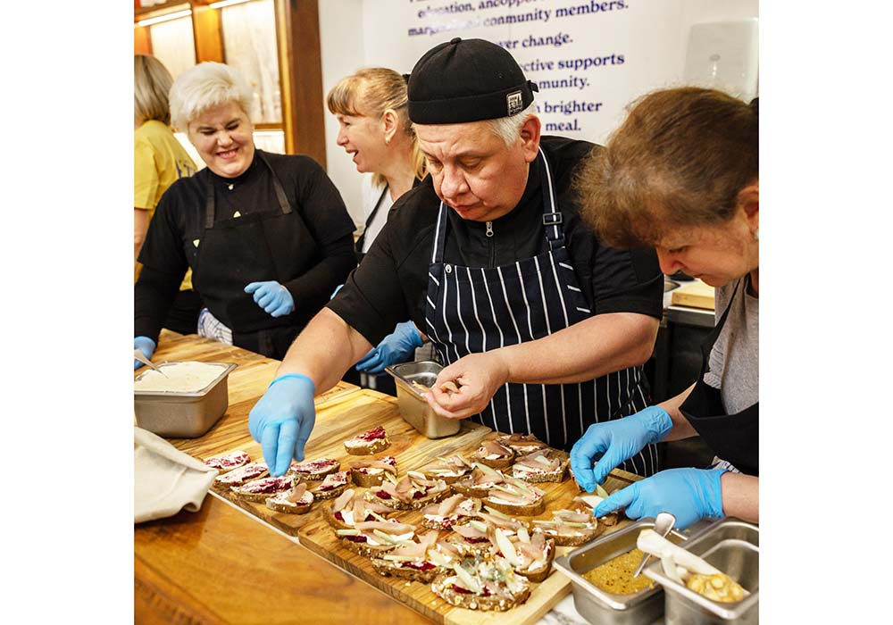 （写真）ウクライナの高級店でシェフとして働いていたヘッドシェフのボリスさん（中央）以外、皆、ホスピタリティ未経験者。それぞれが思い描く家庭料理をベースに、その裏にある意味をディスカッションしながら一緒にメニューを作り上げる。