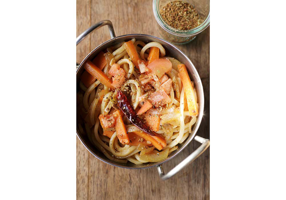 ニンニクとショウガ、ガラムマサラで炒めたインド風の焼きうどん。トマトを加えて蒸し煮し、旨味をアップ。肉なしでも味わい深い。