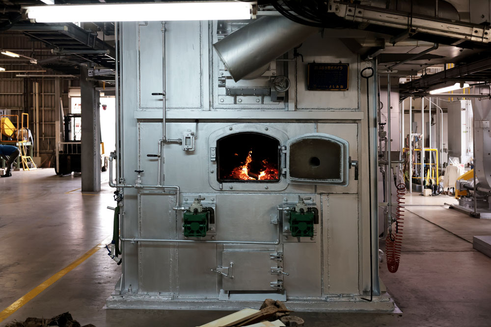 バガス（サトウキビの搾りかす）は、燃料として工場内のボイラーへと送られ、生み出された蒸気によって工場が稼働。「黒糖を製造する工場内は冬でも暑いくらいです」と、友寄さん。