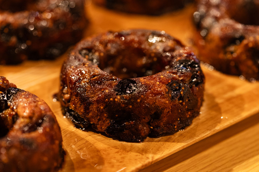 生地はタンパク値の高い超強力粉と黒糖を使い、ほぼミキシングせずに発酵させる。キルシュとハチミツを合わせた水に、ブラックレーズンとグリーンレーズン、クランベリー、ドライイチジクをつけて、伊予柑ピール、ドライリンゴ、クルミ、ピスタチオと合わる。ここに生地を加えてつなぐように混ぜて、発酵させてからオーブンへ。焼き上がりに黒糖シロップをたっぷりと染み込ませる。