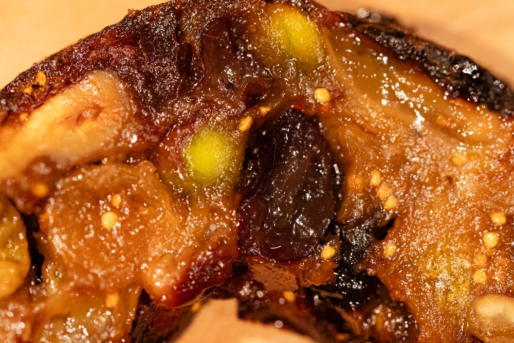 断面は、テリーヌのように果実やナッツがぎっしり詰まり、ふっくら、ジューシー。伊江島産黒糖のシロップがたっぷり染み込み、奥行きのあるハーモニーが口いっぱいに広がる。