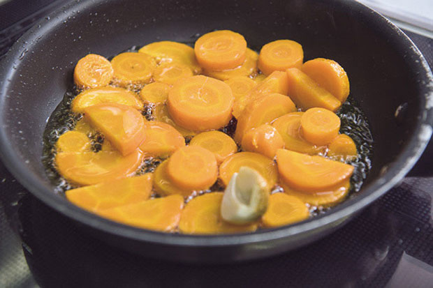 ニンニクの香りが出たら、ニンジンを加える。弱火であまり動かさず揚げ焼きにする。