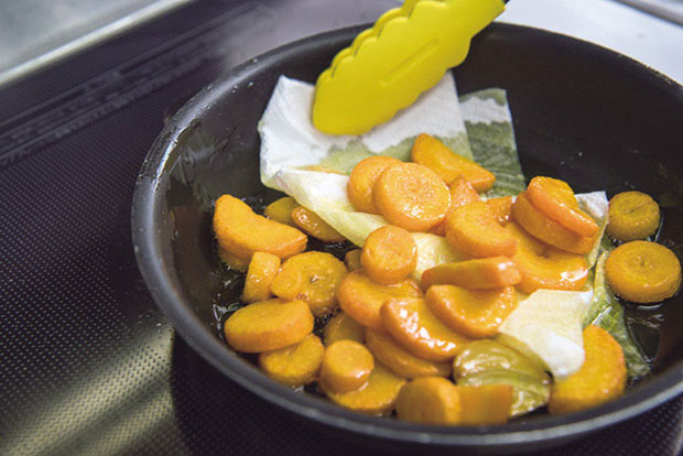 ニンニクを取り除き、キッチンペーパーでフライパンに残った油を吸い取る。