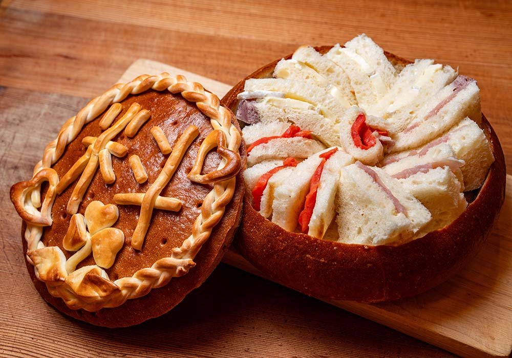 「パン・ド・リオレ」。口当たりやわらかなパン生地には、ほんのりブルーベリー生地が練り込まれている。絶妙な生地と具のバランスで、軽い食べ心地。パンの器の形は丸やハート形のほか、客のイラストに応じて作成することも可能。（￥3,300 / 直径20㎝ / 30ピース、￥7,700 / 26cm / 50ピース ￥11,000 / 30cm / 70ピース）。予約は３日前まで（配送の場合は４日前まで）。