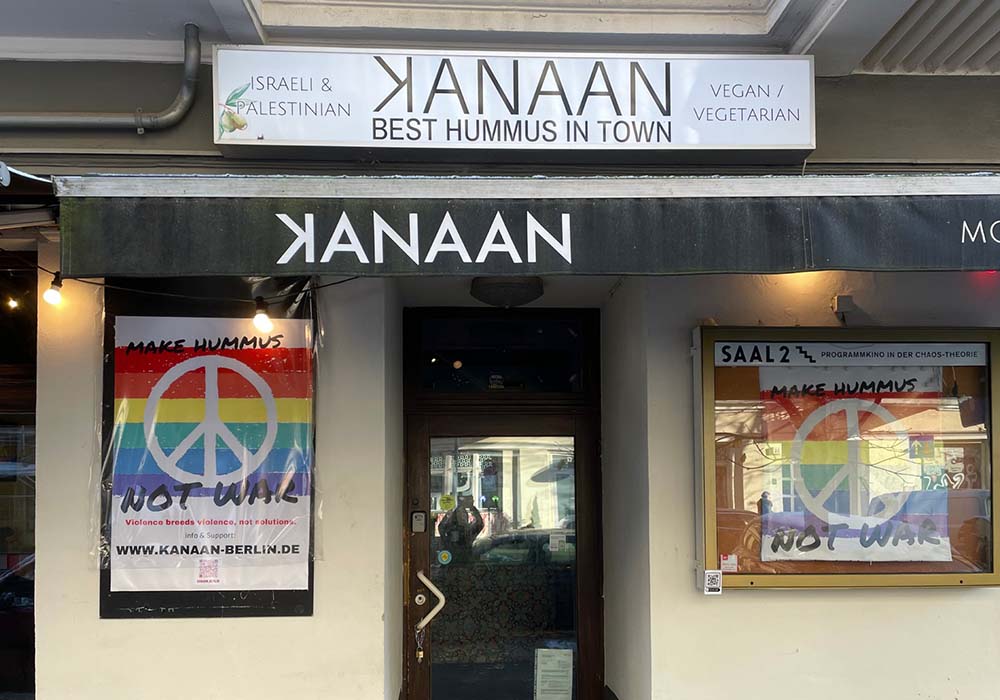 （写真）「Make Hummus Not War」のポスターが入口を飾る、カナンの店先。