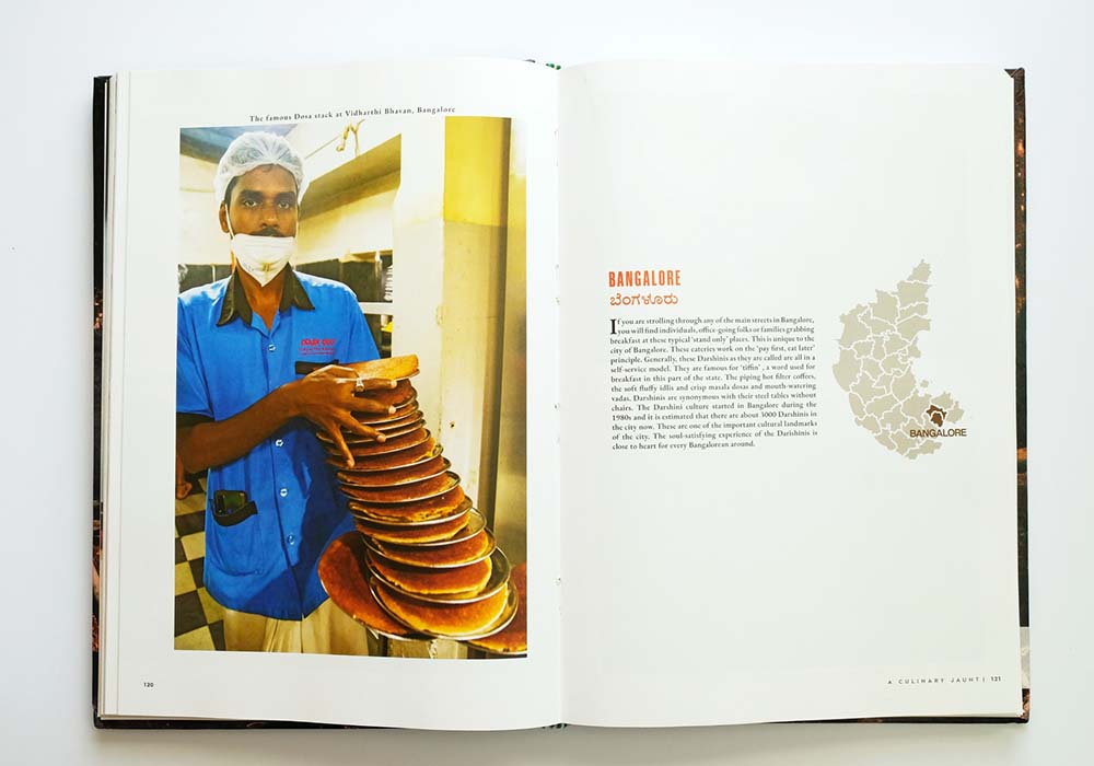 （写真）食べ歩きの街バンガロールの立ち食い軽食屋ダルシニで、名物ドーサを運ぶ男性。バンガロールのドーサは肉厚でモチモチした食感が特徴。ダルシニは現在市内に3000軒あり、街の重要な文化となっている。