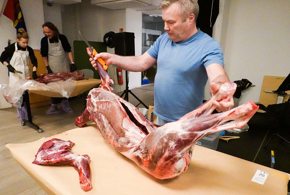 （写真）ニーモさんの実演の後は、各自で肉を解体する。食品ロスが出ないように、自然に感謝して「すべてを使い切る」のがサーミの心得だ。脂肪部分は捨てずに肉と混ぜて肉団子にし、骨は鍋料理でブイヨンとして利用。鍋料理で出た残り汁はソースにしたり、コップに入れてそのまま栄養たっぷりのドリンクとして飲む。ちなみに塩漬け用の塩はかけすぎないことが大事とニーモさん。