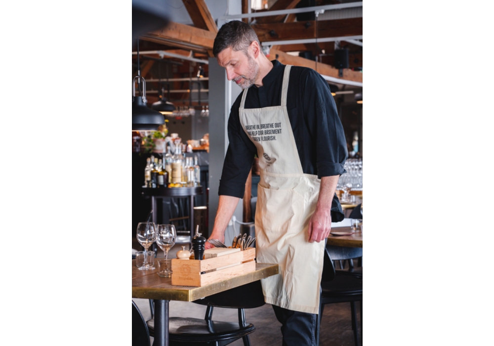 text by Jin Sakiko / photographs by Daniel Tobar （写真）特別な処理を施された生地がレストラン内の二酸化炭素を捕捉するという、画期的なエプロン。 資源を枯渇させるのではなく、すべての地球環境にプラスの影響を与える“プラネット・ポジティブ”を目指すプロジェクトだ。