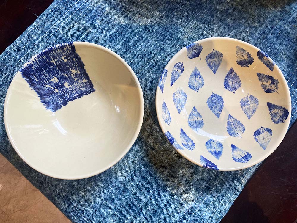 （写真）葉や生地を使うエコ・プリントのコレクションでは、人の手で絵付けをするのではなく、アザミの一種ビリーゴートウィードの葉やジュート（黄麻）に絵の具を染み込ませ、陶器に貼り付け、模様を転写する。プレート各119000ベトナムドン～（直径18cm～）。