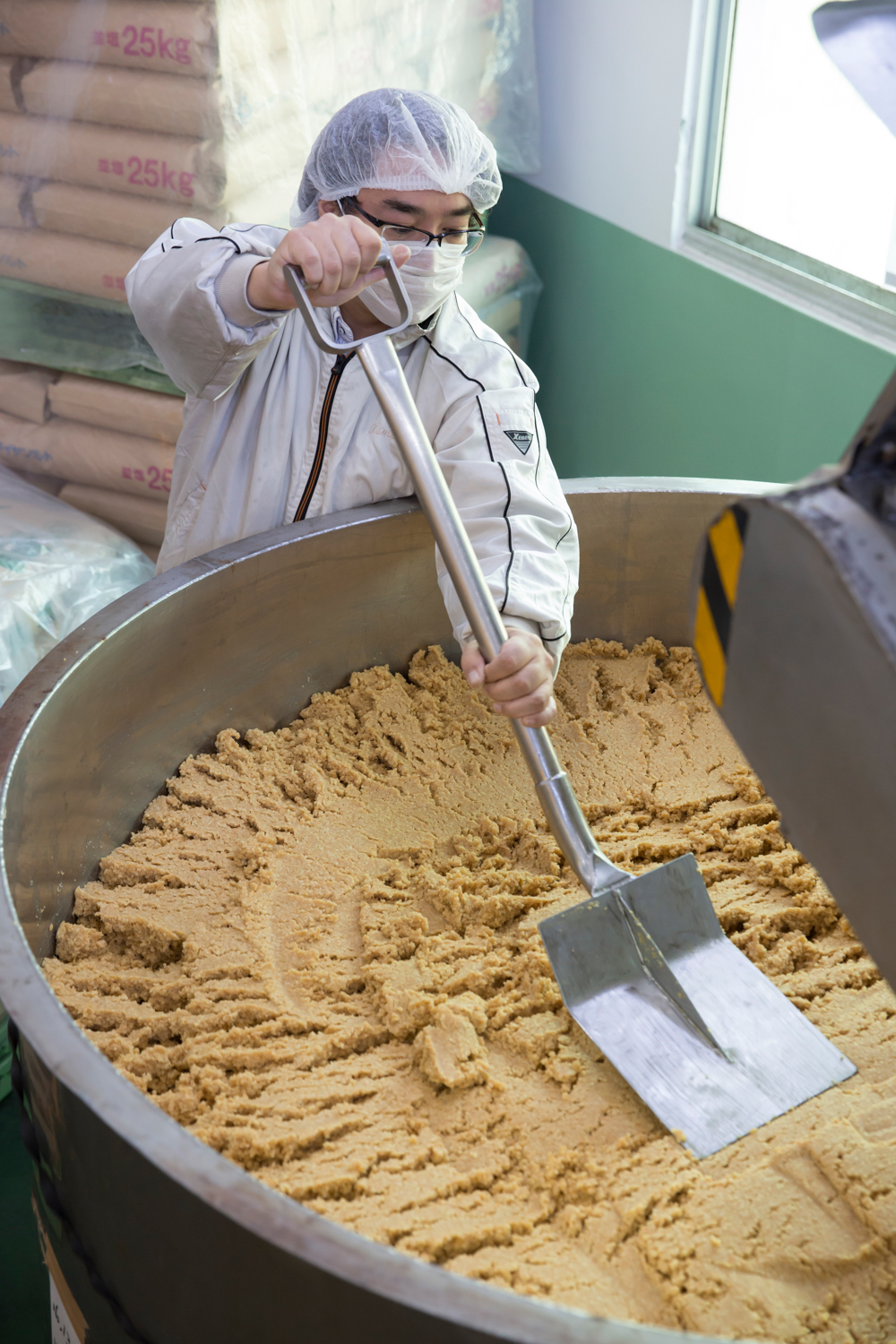 麹と大豆、塩が混ざり、味噌のもとができたら、混ぜながら空気を抜き、その後、発酵、熟成させる。