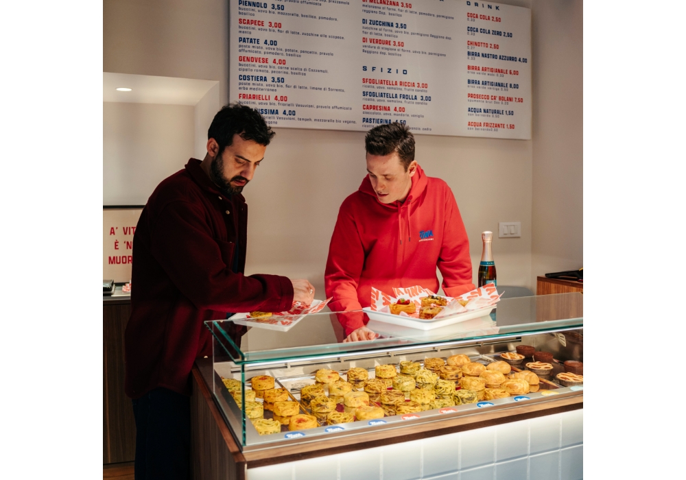 店内のショーケースに焼き上がったフリッタティーナを並べるエドアルドとフランチェスコ。